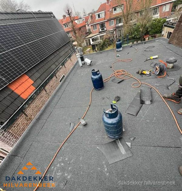 Daklekkage repareren met brandgereedschap op plat dak in Hilvarenbeek