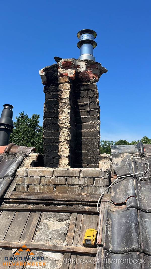 Beschadigde schoorsteen met nieuwe rookgasafvoer op oud dak in Hilvarenbeek Beschadigde schoorsteen met nieuwe rookgasafvoer op oud dak in Hilvarenbeek