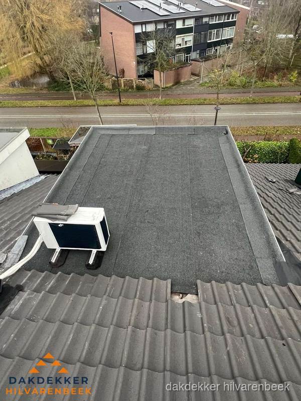 Plat dak inspectie met bitumen bedekking naast schuin pannendak in Hilvarenbeek Plat dak inspectie met bitumen bedekking naast schuin pannendak in Hilvarenbeek
