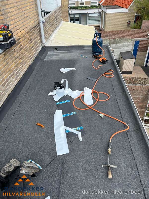 Dakdekkers bezig met bitumen dakbedekking in Hilvarenbeek
