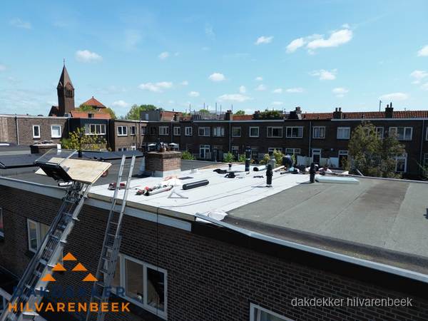 Dakdekkers aan het werk op plat dak in Hilvarenbeek