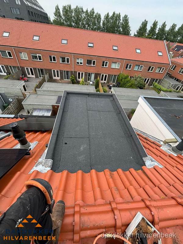 Bitumen dak reparatie op plat dak tussen dakpannen in Hilvarenbeek